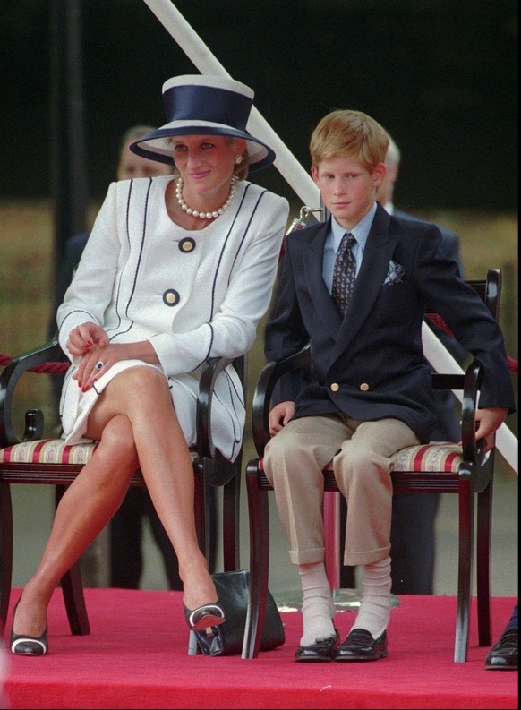 FILE - In this Aug. 19, 1995 file photo, Britain's Princess Diana, left, sits next to her younger son Prince Harry during V-J Day celebrations in London. Britain's Prince Harry said in mid J ...