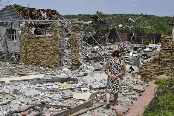 An elderly woman walks next to a building damaged by an overnight missile strike in Sloviansk, Ukraine, Wednesday, June 1, 2022. (AP Photo/Andriy Andriyenko)