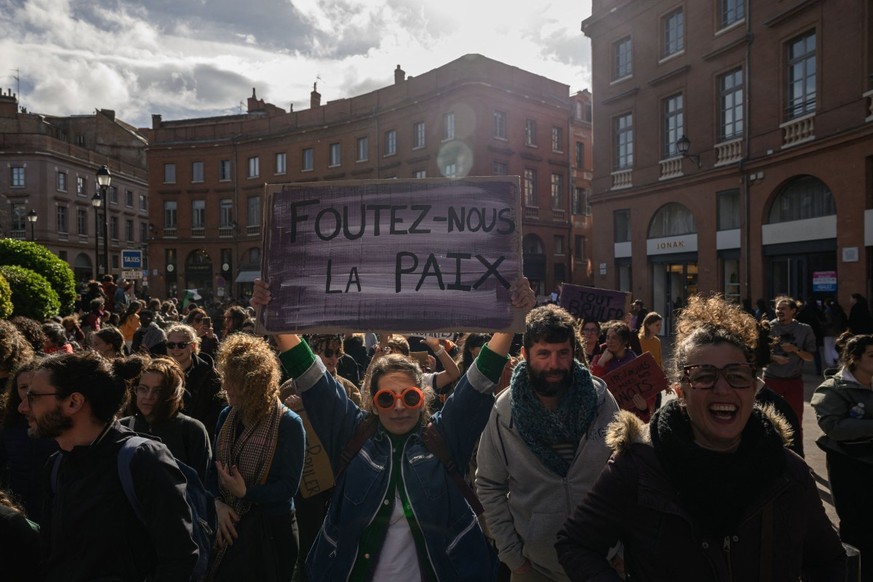 (FILES) A protester (C) holds a placard reading "Leave us in peace" during a march marking the International Women's rights Day , in Toulouse, southwestern France, on March 8, 2025. The ...
