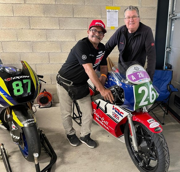 Carlos Lavado (à gauche) et Georges Chatelain avec deux bolides: la 87 est une moto2 datant de 2018 et pilotée par Rémy Gardner; la 26 est une Honda RS-R, année 1985 pilotée par Joey Dunlop.