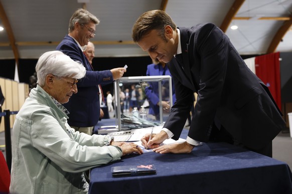 epaselect epa11464511 French President Emmanuel Macron (R) votes in the second round of French parliamentary elections at polling station in Le Touquet-Paris-Plage, northern France, France, 07 July 20 ...