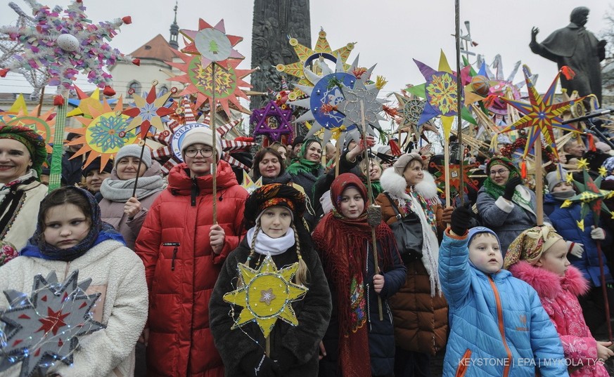 epa10395907 Ukrainians sing Christmas carols as they carry decorated stars of Bethlehem during a parade in downtown Lviv, Western Ukraine, 08 January 2023 as a part of Christmas celebrations amid the  ...