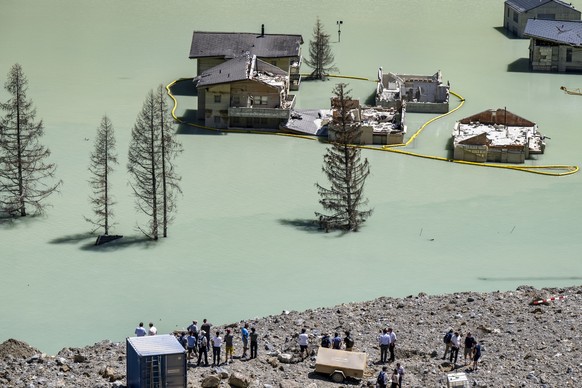 Residents of the Loetschental Valley discover the destroyed houses and a cross marking the site of the destroyed church during a commemorative ceremony, one year after the Blatten landslide, in Blatte ...