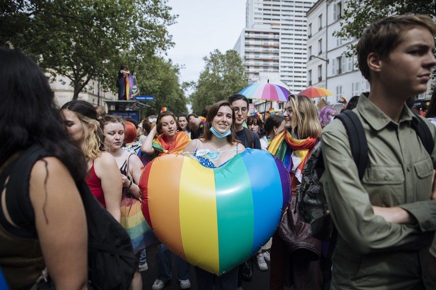 FILE - A participant holds a rainbow heart during the annual Gay Pride march in Paris, June 26, 2021. The National Assembly approved a new law unanimously Tuesday Jan. 25, 2022 evening, putting into l ...