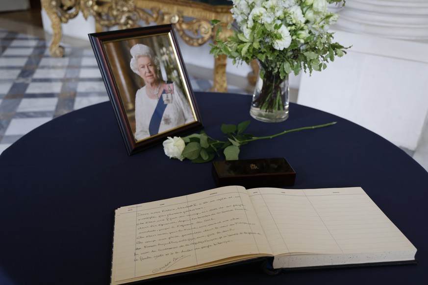 epa10173262 The condolence book signed by French Prime Minister Elisabeth Borne next to a portrait of late British Queen Elizabeth II is displayed at the British Embassy in Paris, France, 09 September ...