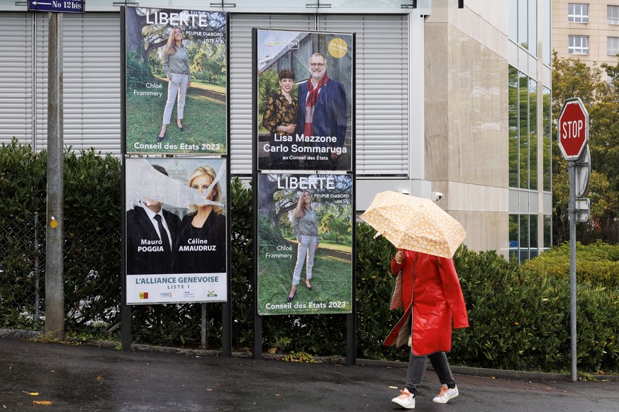 Une femme passe devant Les affiches de Chloe Frammery - Liberte / GE, de Lisa Mazzone - Les Verts / GE et Carlo Sommaruga - Parti socialiste / GE, et de l&#039;affiche dechriee de Mauro Poggia - MCG / ...