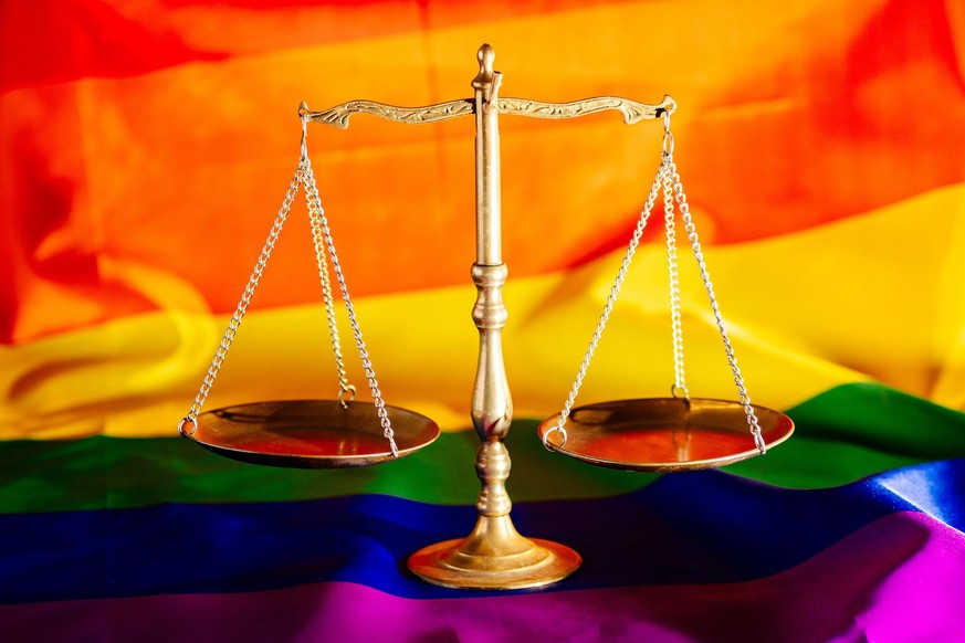 Scales of justice symbol of law and justice with lgbt flag in rainbow colours. Lgbt rights and law