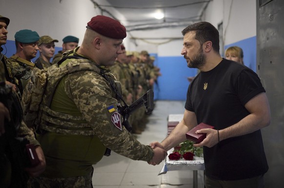 epa10840752 A handout picture made available by the presidential press service shows Ukrainian President Volodymyr Zelensky (R) present a state award to a Ukrainian serviceman during his working visit ...