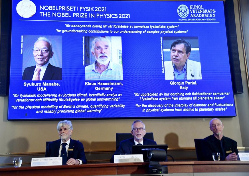 Secretary General of the Royal Swedish Academy of Sciences Goran Hansson, center, flanked at left by member of the Nobel Committee for Physics Thors Hans Hansson, left, and member of the Nobel Committ ...