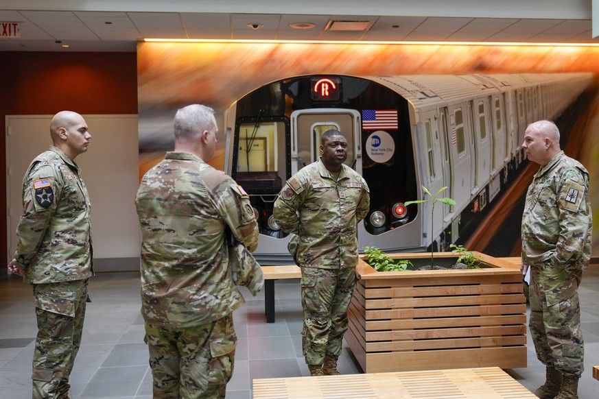 Members of the Armed Forces including the National Guard wait in the lobby of the New York City Mass Transit Authority Rail Control Center before the start of a news conference with Gov. Hochul, Wedne ...