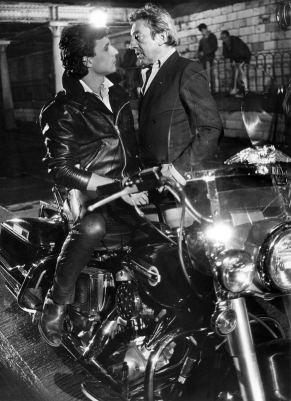 Der franzoesische Chansonnier, Fotograf und Schauspieler Serge Gainsbourg (1928-1991) und Thierry de Carbonniere auf der Harley Davidson waehrend den Aufnahmen am 19. Oktober 1984 in Paris zu Gainsbou ...