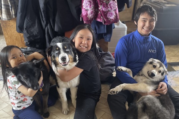In this photo provided by Mandy Iworrigan is Nanuq, in the middle with Brooklyn Faith, after the 1-year-old Australian shepherd was returned to Gambell, Alaska, on April 6, 2023, after it disappeared  ...