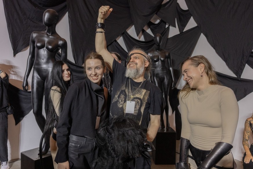 Co-founder of Bob Basset brand and artist Serhii Petrov (C) and his daughter designer Arina Petrova (C-L) acknowledge the audience after their presentation during the Ukrainian Fashion Week in The Mys ...