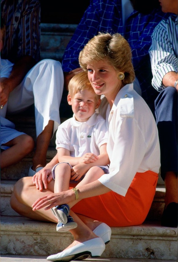 PALMA, SPAIN - AUGUST 13 1988: Diana, Princess Of Wales, Sitting On The Steps Of The Marivent Palace With Her Son, Prince Harry, Sitting On Her Lap At A Photocall During Their Summer Holiday. Prince H ...