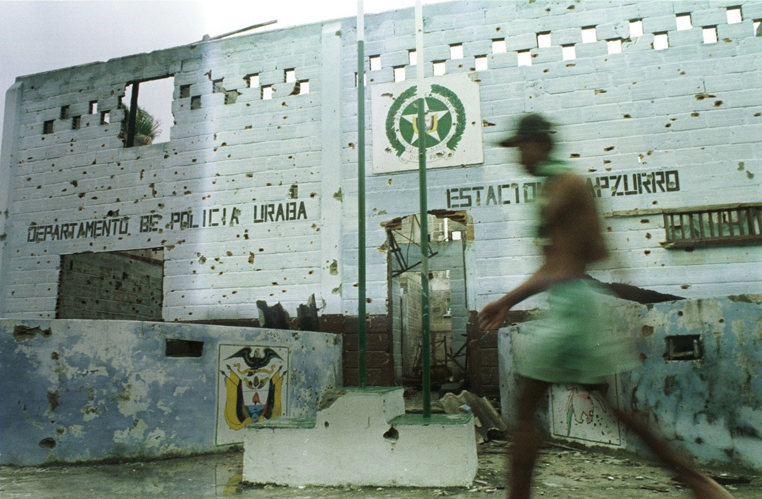 A local fisherman passes the remains the police station that was attacked on April 21, 1999 by soldiers with the 57th front of the Revolutionary Armed Forces of Colombia (FARC ) in the border town of  ...