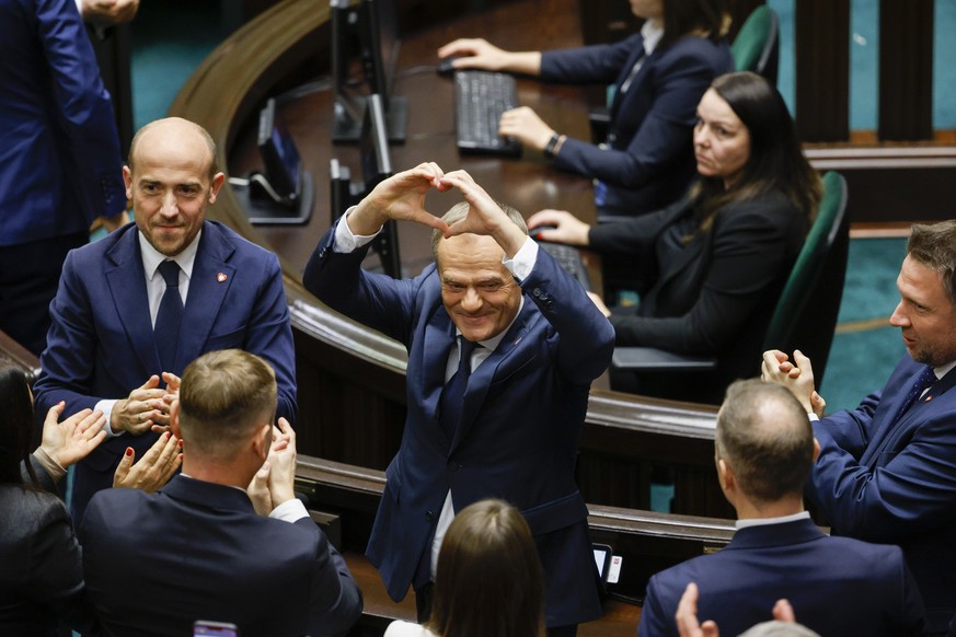 Donald Tusk shows a heart with his hands to lawmakers after he was elected as Poland&#039;s Prime Minister at the parliament in Warsaw, Poland, Monday Dec. 11, 2023. (AP Photo/Michal Dyjuk)