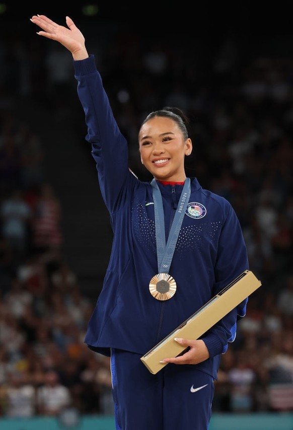 PARIS, FRANCE - AUGUST 04: Bronze medalist Sunisa Lee of Team United States waves from the podium during the medal ceremony for the Artistic Gymnastics Women&#039;s Uneven Bars Final on day nine of th ...