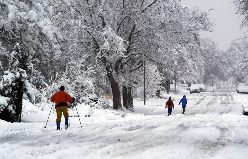 David Ritchey skis along a snow-covered road, following his wife, Barb Miller, and his daughter Jena Ritchey, Saturday, Dec. 30, 2006, in Albuquerque, N.M. The latest storm to hit New Mexico shut down ...