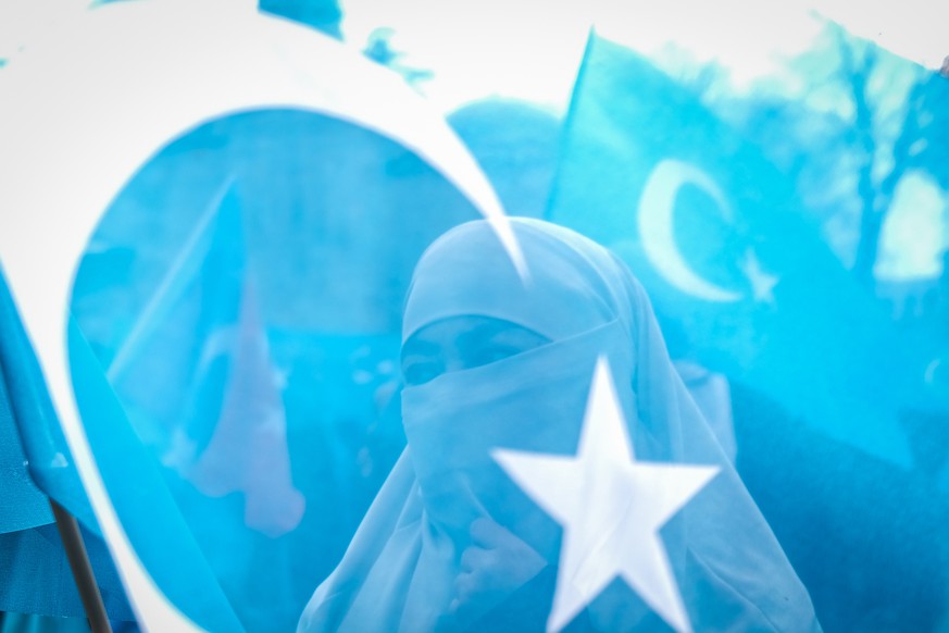epa09095821 Uyghur protestors who have not heard from their families living in East Turkestan hold placards and Uyghur flags during a protest against China, in Istanbul, Turkey, 25 March 2021. Chinese ...