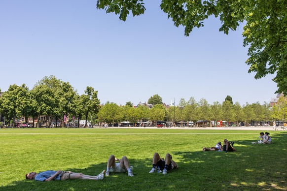 epa13049401 People seek shade at Museumplein in Amsterdam's city center, the Netherlands, 19 June 2026. Due to the warm weather, the National Heat Plan is in effect nationwide. EPA/DINGENA MOL