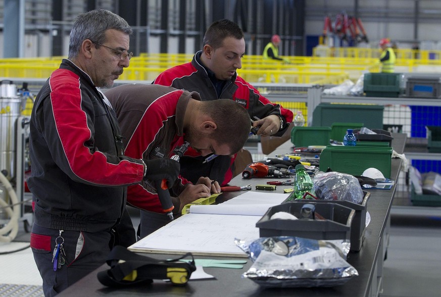 epa03552494 Workers seen at the Cameri F-35 airplane factory, 20 kilometers from Novara, northem Italy, 23 January 2013. According to US company Lockheed Martin, the Italian government participates in ...