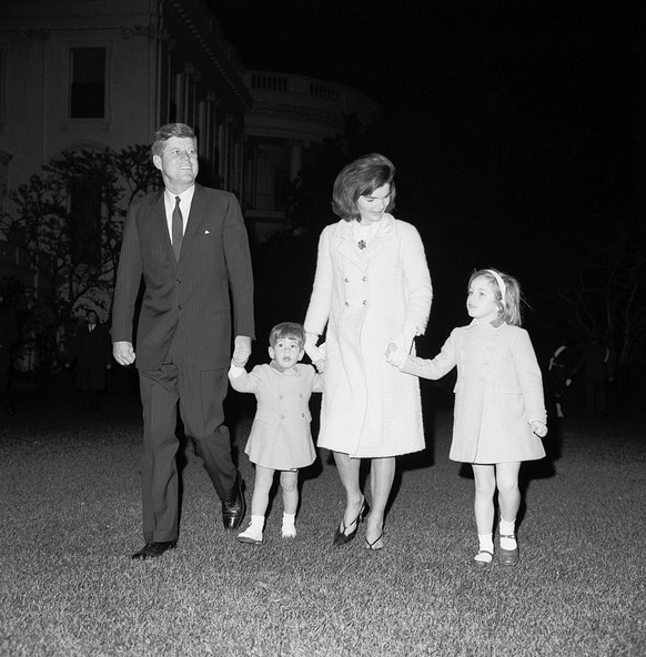 Jackie and John Kennedy walk with their two children, John and Caroline.