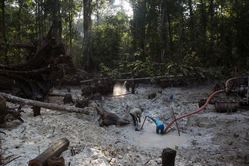 FILE - Men search for gold at an illegal gold mine in the Amazon jungle in the Itaituba area of Para state, Brazil, Aug. 21, 2020. Much like brown and black tributaries that feed the Amazon River, gol ...