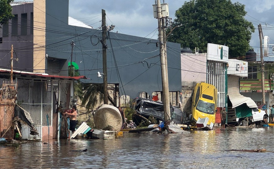 epa12446168 A flooded street with debris caused by heavy rains in Poza Rica, Mexico, 10 October 2025. Dozens of people were killed and several remain missing after heavy rains caused widespread floodi ...