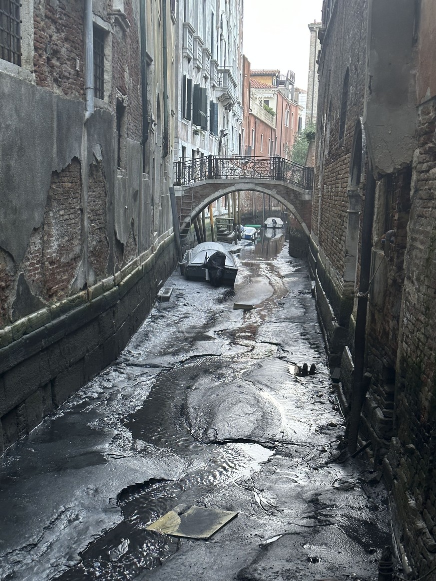 Boats are docked on a dry canal during a low tide in Venice, Italy, Monday, Feb. 20, 2023. (AP Photo/Luigi Costantini)