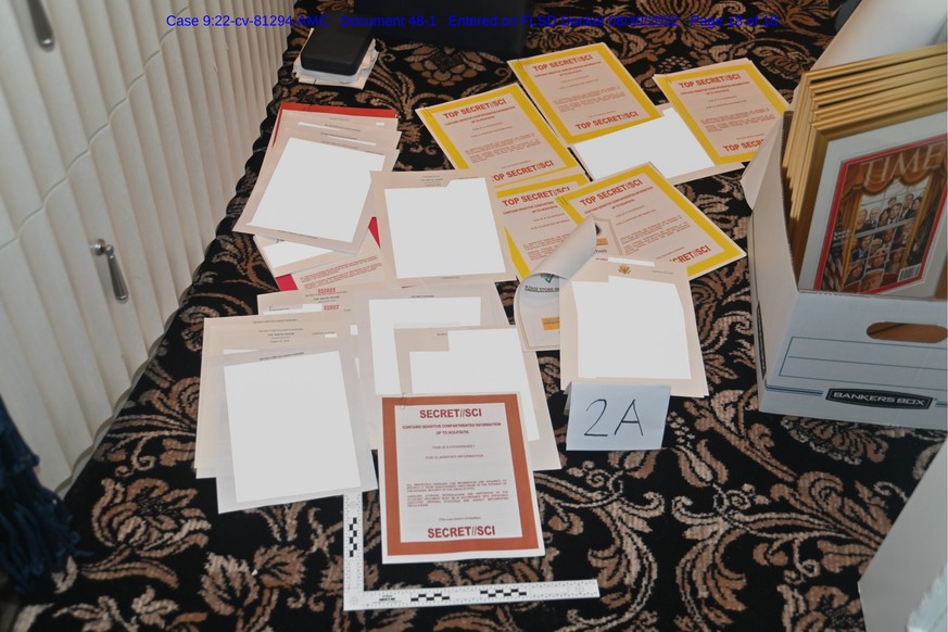 This image contained in a court filing by the Department of Justice on Aug. 30, 2022, and partially obscured by the source, shows a photo of documents seized during the Aug. 8 search by the FBI of for ...