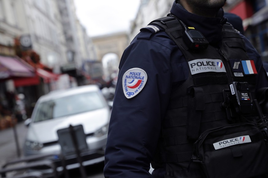 epa10377081 A French Police officer secures the perimeter on 'Rue d'Enghien' following a shooting incident near a Kurdish cultural centre in Paris, France, 23 December 2022. The Paris P ...