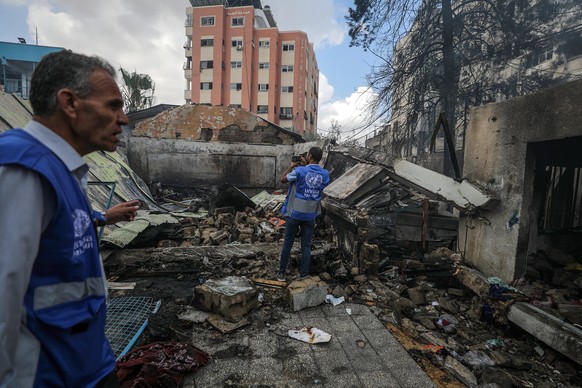 epa11339656 UNRWA employees inspect a destroyed United Nations school following an air strike in Al Nuseirat refugee camp, central Gaza Strip, 14 May 2024. At least six people were killed in the strik ...