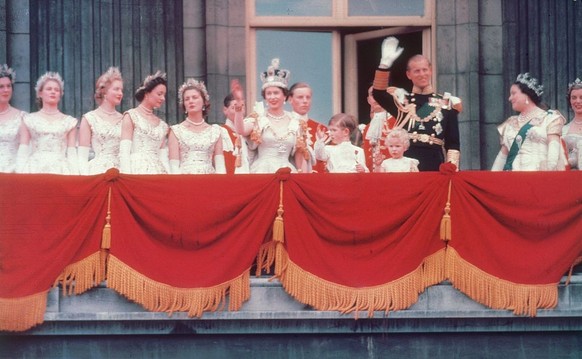 2nd June 1953: The Duke of Edinburgh and the newly crowned Queen Elizabeth II wave to the crowd from the balcony at Buckingham Palace. Her children Prince Charles and Princess Anne stand with her. (Ph ...