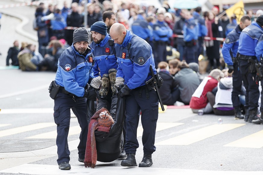 Des policiers evacuent les militants d'Extinction Rebellion qui bloquent les rues de Lausanne lors d'une action de bloquage d' Extinction Rebellion, XR, ce samedi, 14 decembre 2019 a Lausanne. Les man ...