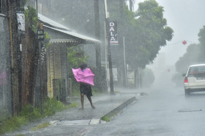 A woman fights Gale force winds in the Indian Ocean Island of Mauritius Wednesday Feb. 2, 2022. Forecasts say Tropical Cyclone Batsirai is increasing in intensity and is expected to pass north of the  ...