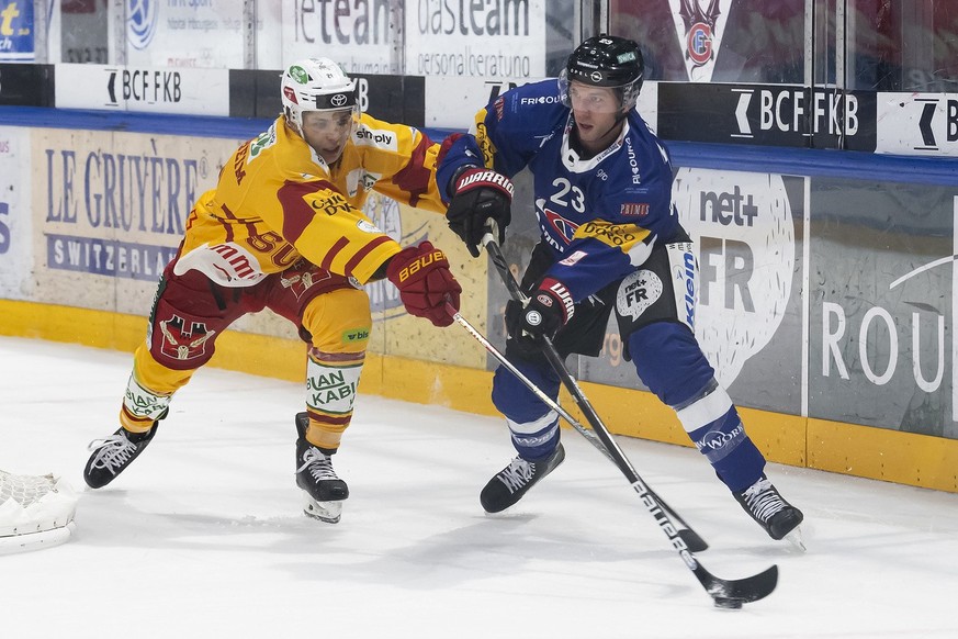 Langnaus Bastian Guggenheim, links, und der Freiburger Samuel Walser, rechts, kaempfen um den Puck, beim Eishockey Meisterschaftsspiel der National League A zwischen dem HC Fribourg Gotteron und den S ...