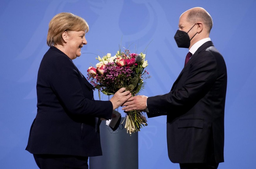 New elected German Chancellor Olaf Scholz, right, gives flowers to former Chancellor Angela Merkel during a handover ceremony in the chancellery in Berlin, Wednesday, Dec. 8, 2021. (Photo/Markus Schre ...