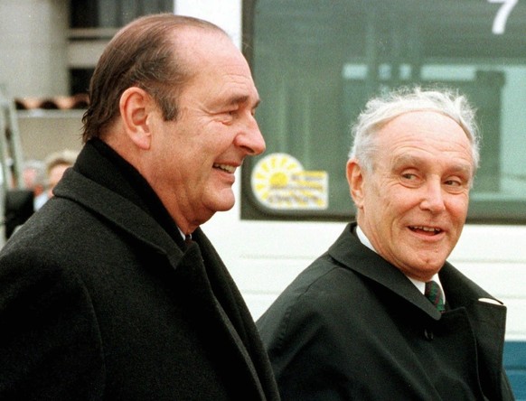 French President Jacques Chirac (l.) is welcomed by Swiss President Flavio Cotti on Zuerich airport, Wednesday, October28, 1998 and escorted to the car while a heavy wind is blowing that caused a land ...