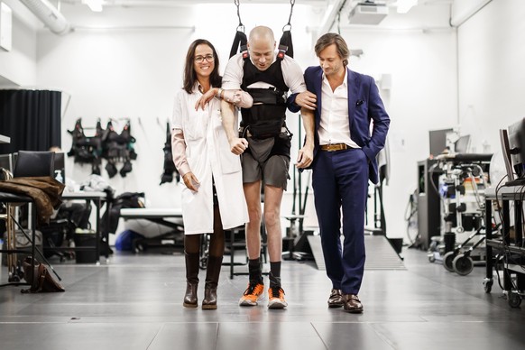 EMBARGO UNTIL OCTOBER 31, 19:00 CET - Swiss paraplegic patient Sebastian Tobler, center, walks thanks to the electrical stimulation of his spinal cord surrounded by Professor Gregoire Courtine, right, ...