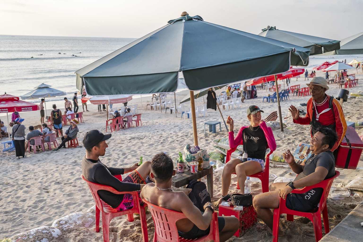 epa10935730 Foreign tourists sit at a beach in Kuta, Bali, Indonesia, 24 October 2023. Starting February 2024, the Provincial Government of Bali will implement a 10 USD tourist tax for every foreign t ...