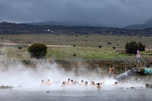 epa11795003 Israelis enjoy a hot spring at Orvim Eliyon Reservoir in the annexed Golan Heights, near the border with Syria, 27 December 2024. EPA/ATEF SAFADI