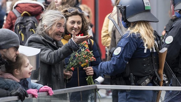Zwei Frauen diskutieren mit einer Polizistin bei einer Demonstration gegen die verordneten Corona Schutzmassnahmen, am Samstag, 20. Maerz 2021, in Bern. (KEYSTONE/Peter Schneider)