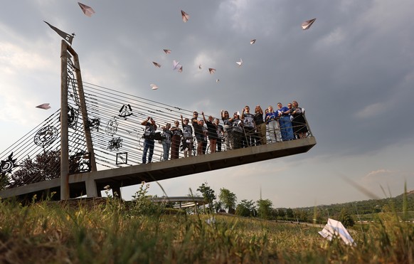 epaselect epa11483964 Local people lunch paper airplanes during a &#039;Last Flight&#039; mourning ceremony on the tenth anniversary of the disaster of the plane MH17 near village of Grabovo, in Donet ...