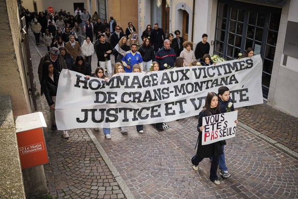 epa12694955 People walk in silence as about a thousand people gather to pay tribute to the victims of the tragedy in Crans-Montana and to call for justice and truth, Lutry, Switzerland, 31 January 202 ...