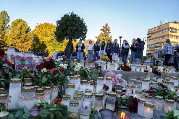 Des personnes déposent des fleurs et allument des bougies sur Stortorvet deux jours après un attentat à Kongsberg, en Norvège, le 15 octobre 2021.