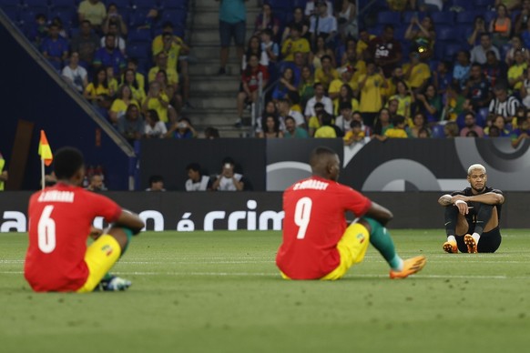 Players sit on the ground before an international friendly soccer match between Brazil and Guinea at the RCDE Stadium in Barcelona, Spain, Saturday, June 17, 2023. (AP Photo/Joan Monfort)