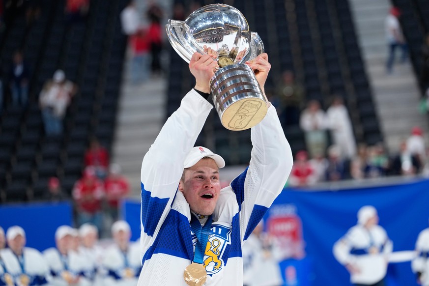 Finland's Jesse Puljujarvi celebrates with trophy after winning the 2026 IIHF Men's Ice Hockey World Championship final match against Switzerland, in Zurich, Switzerland, Sunday, May 31, 202 ...