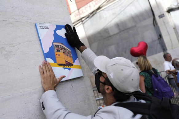 A person that wished to remain anonymous, places a painting showing a funicular with one driver and fifteen passengers, by the downtown stop of the Gloria funicular, a tourist streetcar that derailed  ...