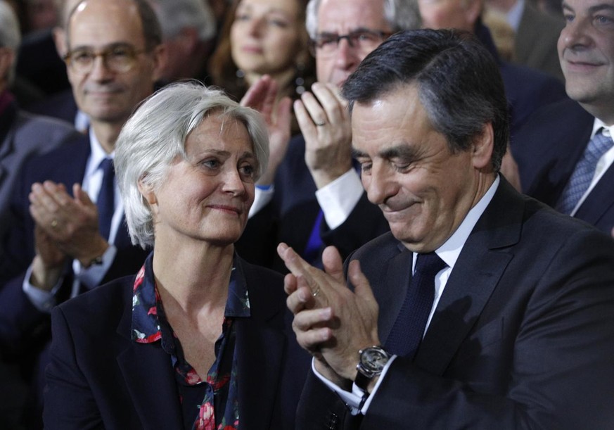 Conservative presidential candidate Francois Fillon applauds while his wife Penelope looks on as they attend a campaign meeting in Paris, Sunday, Jan. 29, 2017. Financial prosecutors are investigating ...