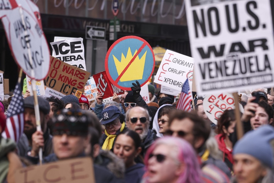 epa12643419 People hold placards while marching during a 'No war, no kings, no ICE' protest in New York, New York, USA, 11 January 2026. Protesters rallied against the Trump administration&# ...